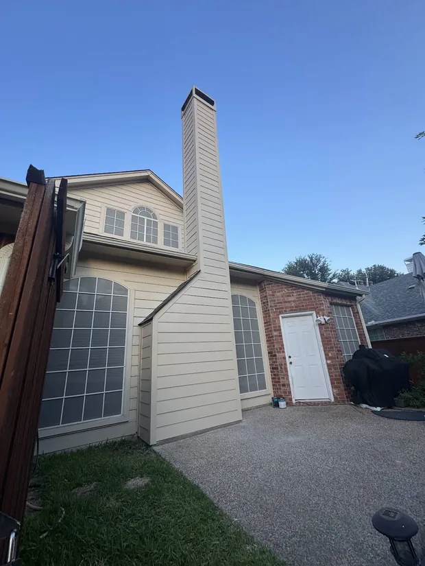 Tall chimney chase finished with new lap siding on a two-storey home