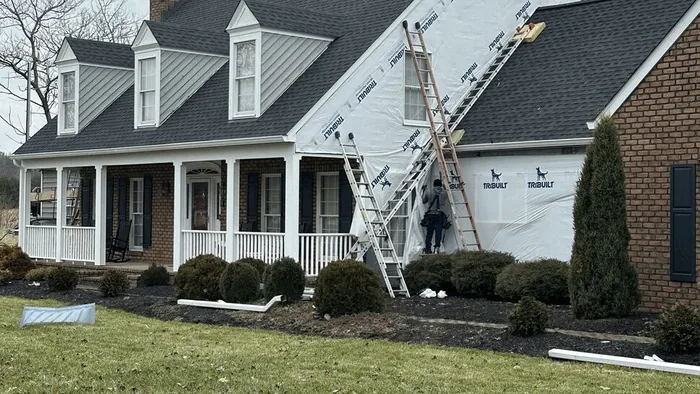 Home wrapped in weather barrier during a siding replacement project